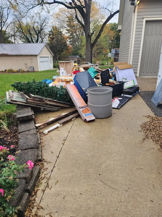 Dumpster being loaded with debris for Estate Cleanout Dumpster Rental in Oshtemo